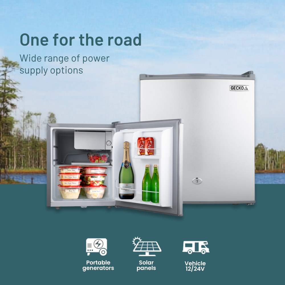 Portable refrigerator with open door showing drinks, set against a scenic background with trees and water.