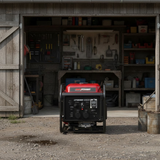 Portable generator in front of a workshop with tools and equipment.