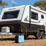 Camper trailer with a generator and power cord in an outdoor setting