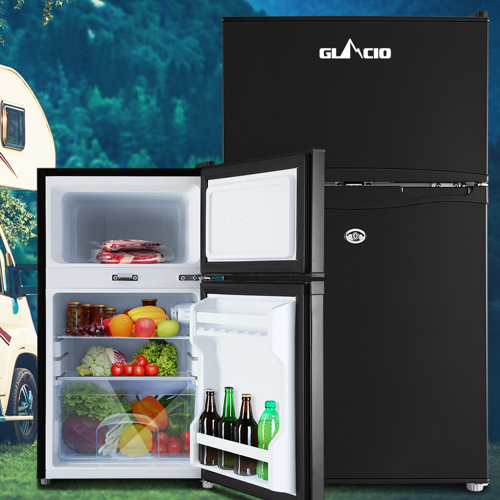 Black refrigerator with open door showing food items against a scenic background