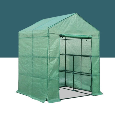 A green greenhouse made of a durable tarp-like material, supported by a black metal frame. It has a pitched roof and a partially open front showing the framework inside.