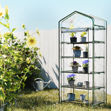 "A compact, multi-tiered greenhouse standing in a sunlit garden, surrounded by plants, designed for small space gardening."