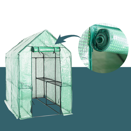 A full view of a green, transparent greenhouse with a roll-up door partially secured at the top. An inset circle highlights a close-up of the rolled-up door with ties