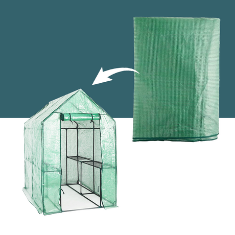 A full view of the green greenhouse with a roll-up front entrance and an arrow pointing to a folded, spare greenhouse cover laid flat, highlighting its material