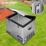 Portable refrigerator with AC/DC power options on a grassy background
