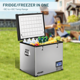 Kölner fridge/freezer with food items on a grassy area with people in the background