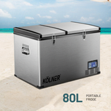 Kölner 80L portable fridge on a beach with turquoise water and blue sky.