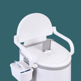 A close-up view against a teal background focusing on the upper portion of the toilet. It details the backrest, the armrests, and the detachable tissue holder/storage bin hanging on the left side.