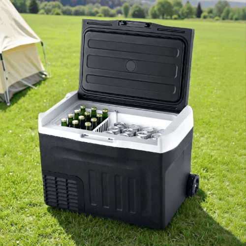 New Aim 30L 12V/24V/240V Portable Fridge Freezer with drinks on grass near a tent