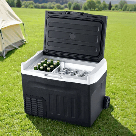 New Aim 30L 12V/24V/240V Portable Fridge Freezer with drinks on grass near a tent