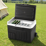 New Aim 30L 12V/24V/240V Portable Fridge Freezer with drinks on grass near a tent