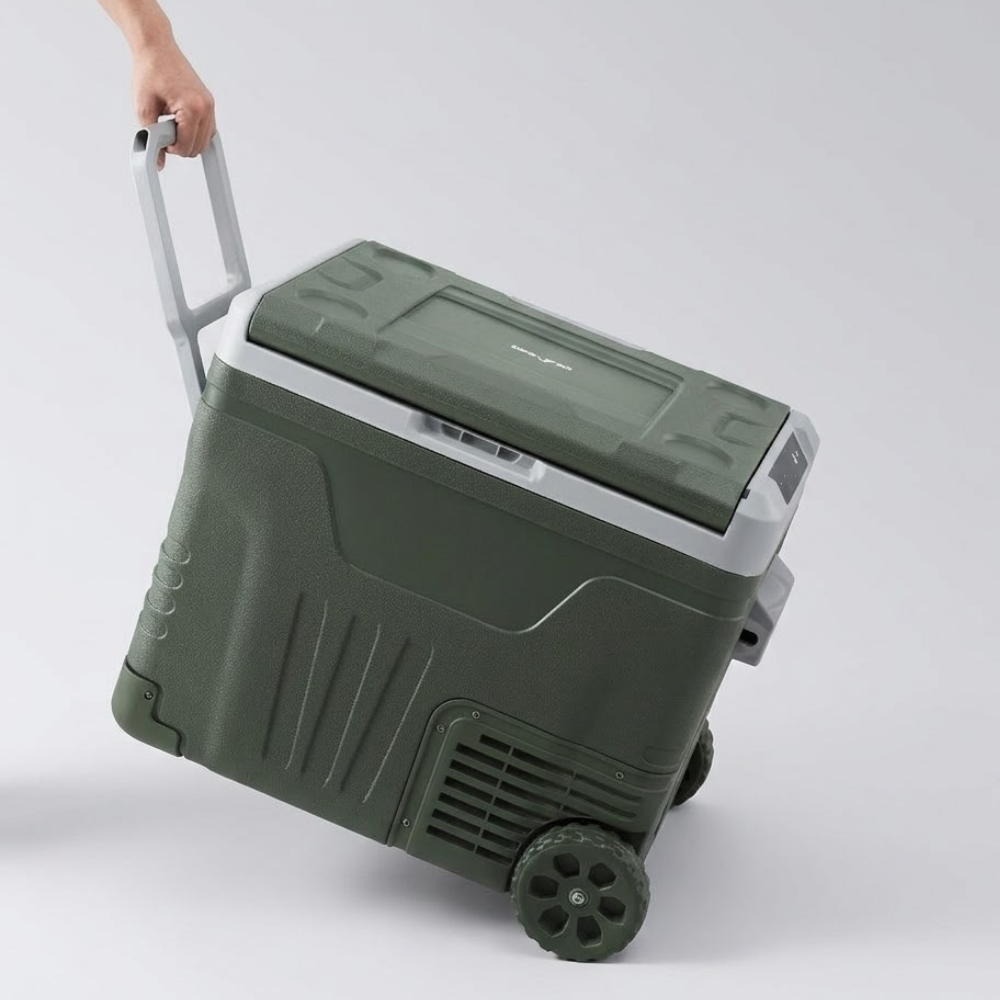 Green cooler with wheels and a hand holding the handle on a white background