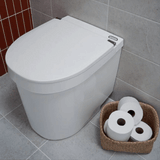 White toilet with a basket of toilet paper on a tiled bathroom floor