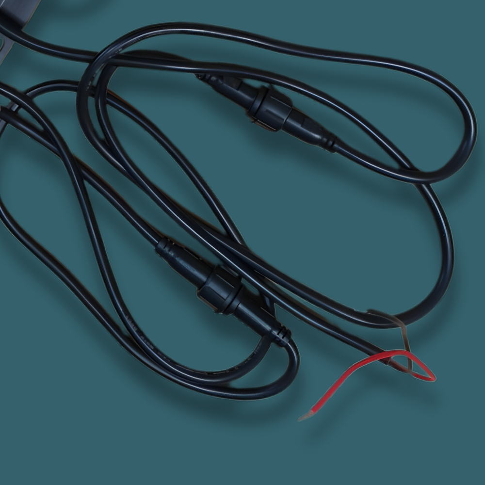 Black electrical wire with connectors on a teal background