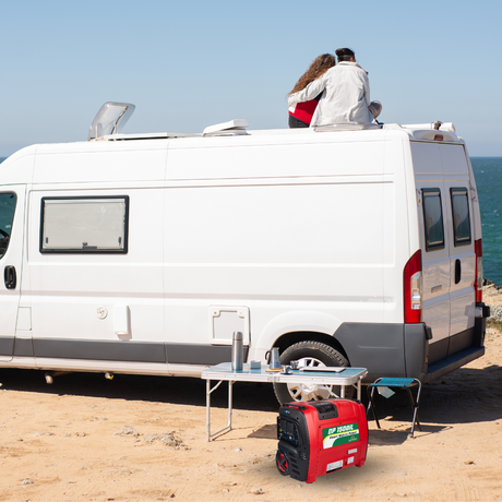Red generator powering a caravan parked on a sandy site.