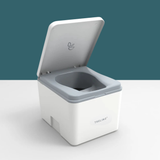 A white and gray portable toilet container with its lid open, shown on a clean white surface against a dark teal background. The brand name 'TRELINO' is visible on the front.