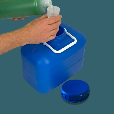Person pouring liquid from a green bottle into a blue container with a white handle.