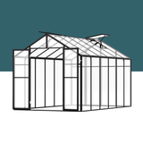 Greenhouse structure with glass panels and metal frame on a white background