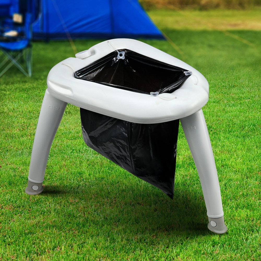 Portable outdoor trash bin with a black bag on a grassy area