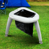 Portable outdoor trash bin with a black bag on a grassy area